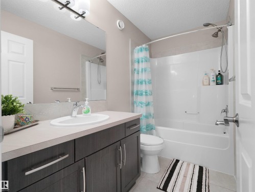 Bathroom featuring a dark wood-finish vanity with a light countertop, an undermount sink, and chrome fixtures - 7827 22 Avenue, Edmonton, AB 