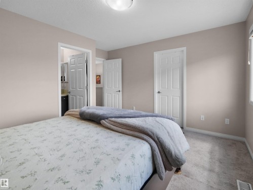Bedroom featuring neutral tone walls, white trim, and carpet flooring - 7827 22 Avenue, Edmonton, AB 