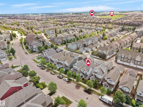 Aerial view of a residential neighborhood with numerous single-family homes and townhomes, featuring mature trees and paved streets - 7827 22 Avenue, Edmonton, AB 