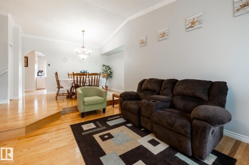 Living area featuring wood-finish flooring, vaulted ceilings, and crown molding - 27 Danforth Crescent, St. Albert, AB 