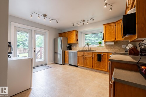 Kitchen featuring light wood cabinetry, stainless steel appliances, and track lighting - 27 Danforth Crescent, St. Albert, AB 