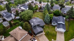 Single-family residence featuring a dark shingle roof, attached garage, and light-toned siding - 