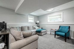 Carpeted room featuring two windows with white trim, a flush-mount ceiling light, and chair rail molding - 
