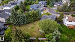 Expansive grassy backyard featuring a fenced perimeter and mature trees - 