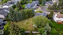 Expansive grassy backyard featuring a fenced perimeter and mature trees - 27 Danforth Crescent, St. Albert, AB 