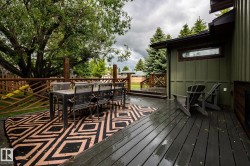 Expansive wood-finish deck with a decorative privacy fence and mature perimeter trees - 