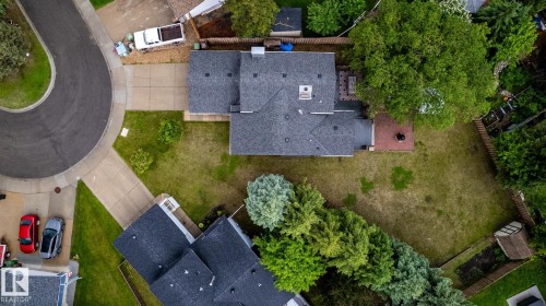 Residence featuring a dark shingle roof, expansive backyard, mature trees, and a concrete driveway - 27 Danforth Crescent, St. Albert, AB 