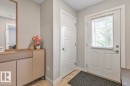 Entryway featuring a paneled door with an integrated window and blinds, a second interior paneled door, and neutral-toned walls - 22 3025 151 Avenue, Edmonton, AB 