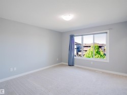 Bright room featuring soft gray walls and light-toned carpeting - 