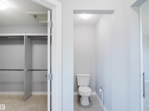 Private water closet with a floor-mounted toilet and tiled flooring - 2526 Wonnacott Loop, Edmonton, AB 