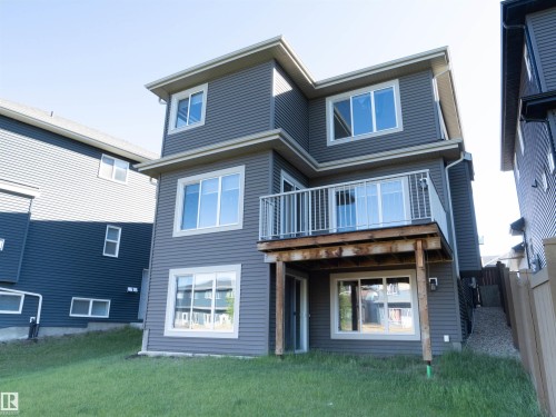 Two-story exterior with horizontal siding, multiple windows, and a second-level balcony with white railings - 2526 Wonnacott Loop, Edmonton, AB 