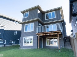 Two-story exterior with horizontal siding, multiple windows, and a second-level balcony with white railings - 