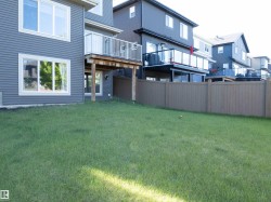 Spacious backyard featuring a grass lawn, privacy fencing, and a ground-level walkout - 