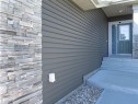 Exterior entry featuring horizontal siding and stacked stone facade - 2526 Wonnacott Loop, Edmonton, AB 