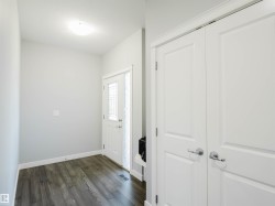 Entryway featuring wood-finish flooring, a white paneled entry door with decorative glass, and a side light - 