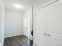 Entryway featuring wood-finish flooring, a white paneled entry door with decorative glass, and a side light - 2526 Wonnacott Loop, Edmonton, AB 