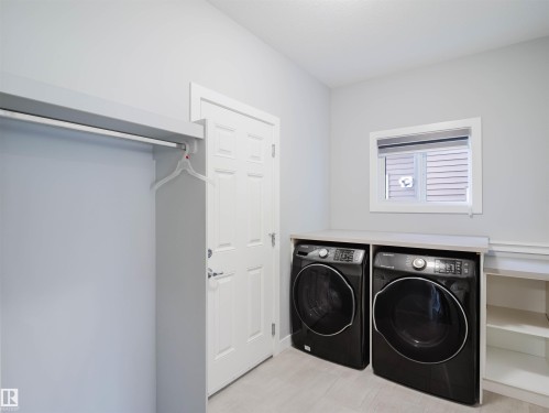 Dedicated laundry area featuring a countertop surface, integrated shelving, and light wood-finish flooring - 2526 Wonnacott Loop, Edmonton, AB 