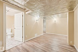 Room featuring a decorative pressed tin ceiling and wood-finish flooring - 