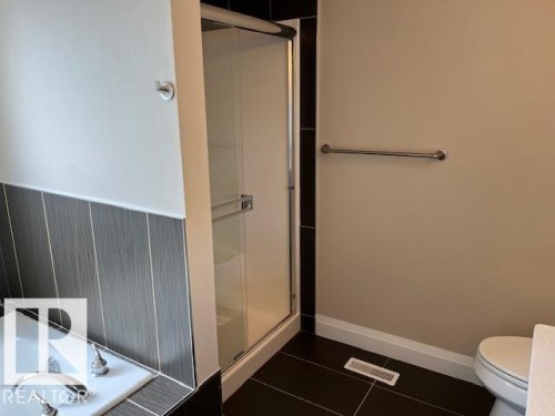 Enclosed glass shower with dark contrasting tile surround - 805 Hodgins Road, Edmonton, AB 