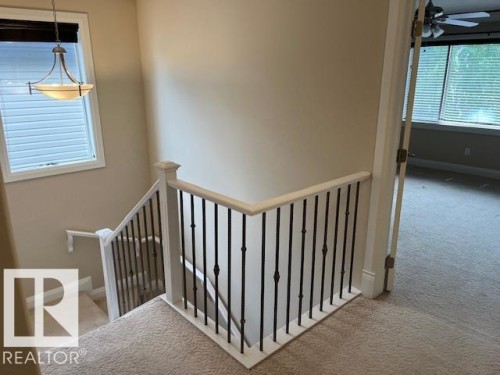 Carpeted landing with white balustrade and black iron spindles - 805 Hodgins Road, Edmonton, AB 