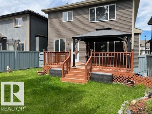 Rear exterior featuring a multi-level wood deck with railings, a built-in gazebo, and a grass lawn - 805 Hodgins Road Nw, Edmonton, AB - Outdoor With Deck Patio Veranda With Exterior