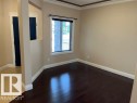 Room with dark wood-finish flooring, light tan walls, and white baseboards - 805 Hodgins Road, Edmonton, AB 