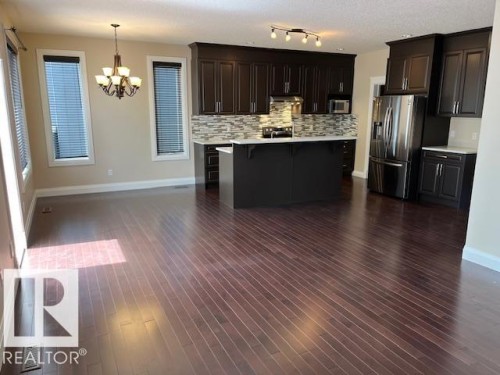 Open-concept kitchen and dining area featuring dark wood-finish flooring - 805 Hodgins Road, Edmonton, AB 