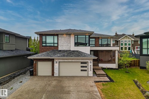 Contemporary residence featuring a multi-material facade with stone accents and dark-frame windows - 4509 Wingfield Bay Bay, Edmonton, AB 