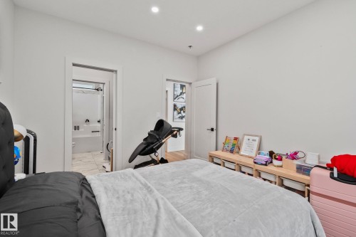 Bedroom featuring light neutral wall paint, recessed lighting, and a white interior door with matte black hardware - 4509 Wingfield Bay Bay, Edmonton, AB 