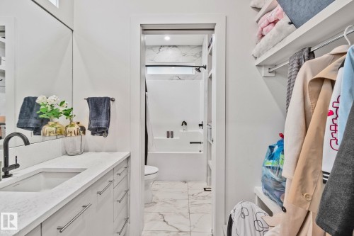Contemporary bathroom vanity featuring a rectangular undermount sink, a matte black faucet, and a light-toned countertop - 4509 Wingfield Bay Bay, Edmonton, AB 