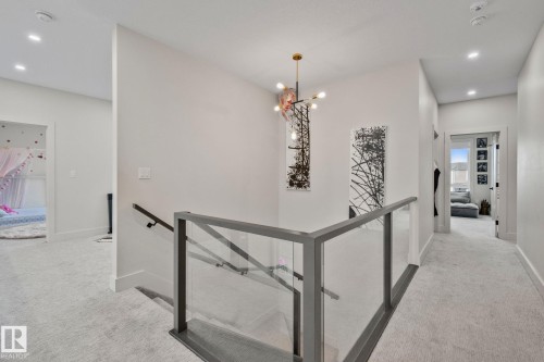 Upper-level landing featuring a contemporary glass and metal railing system - 4509 Wingfield Bay Bay, Edmonton, AB 