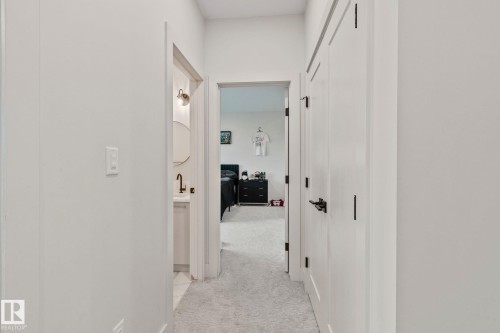 Hallway with light gray carpeting, white walls, and white trim - 4509 Wingfield Bay Bay, Edmonton, AB 