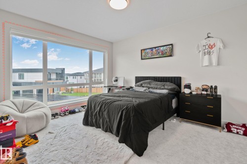Spacious room featuring a large picture window, light-toned carpeting, and white wall finishes - 4509 Wingfield Bay Bay, Edmonton, AB 
