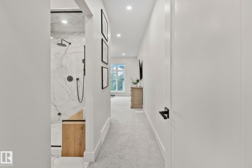 Modern shower enclosure with marble-finish wall tiles, matte black fixtures, and a wood-finish bench - 4509 Wingfield Bay Bay, Edmonton, AB 