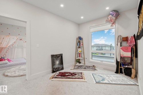 Recessed lighting illuminates a room featuring light gray carpeting and a large window with white trim - 4509 Wingfield Bay Bay, Edmonton, AB 