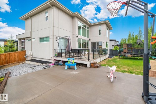 Rear exterior with a concrete patio, wood privacy fencing, and a manicured lawn - 4509 Wingfield Bay Bay, Edmonton, AB 