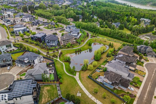 Lakeside community featuring modern residential architecture, winding pathways, mature trees, and a river in the background - 4509 Wingfield Bay Bay, Edmonton, AB 