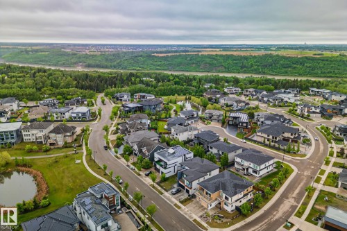 Aerial overview of a residential development featuring diverse architectural styles, curvilinear streets, and landscaped green spaces - 4509 Wingfield Bay Bay, Edmonton, AB 