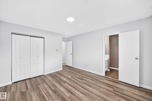 Spacious room featuring wood-finish flooring, light grey walls, and a recessed ceiling light - 1103 56 Street, Edmonton, AB 