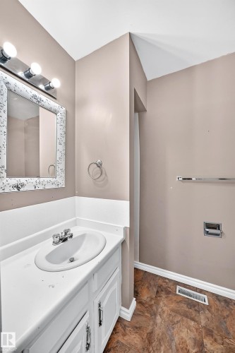 Bathroom featuring a white vanity with integrated sink, coordinating white cabinetry, and a chrome faucet - 1103 56 Street, Edmonton, AB 