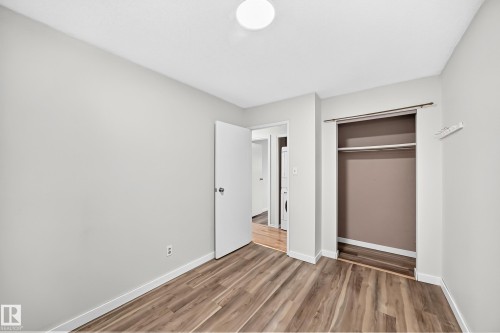 Room featuring wood-finish flooring, light grey painted walls, and white trim - 1103 56 Street, Edmonton, AB 