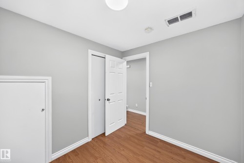 Interior room featuring wood-finish flooring, light gray wall paint, and white trim - 1103 56 Street, Edmonton, AB 