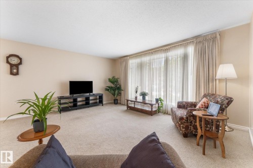 Spacious living area featuring neutral carpet flooring and light-toned wall finishes - 15112 76A Avenue, Edmonton, AB 