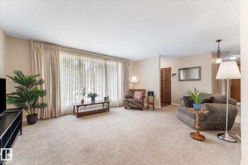 Spacious living area featuring neutral carpeting and light-toned walls - 15112 76A Avenue, Edmonton, AB 