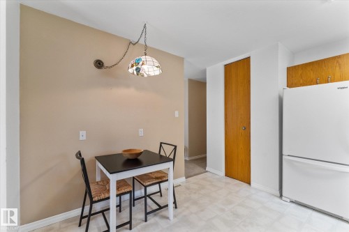 Functional kitchen area featuring a white refrigerator and wood-finish cabinetry - 15112 76A Avenue, Edmonton, AB 