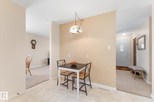 Compact dining area featuring a pendant light fixture, light-toned wall paint, and tile flooring - 15112 76A Avenue, Edmonton, AB 