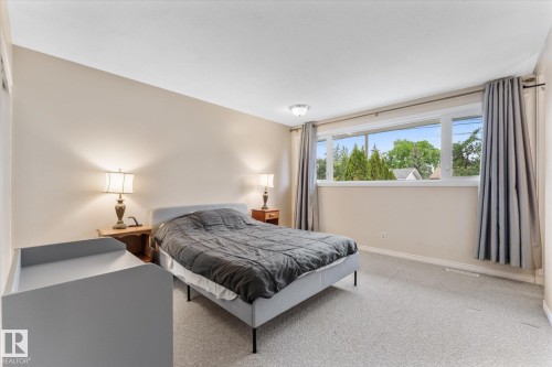 Carpeted bedroom with a large transom window providing abundant natural light - 15112 76A Avenue, Edmonton, AB 