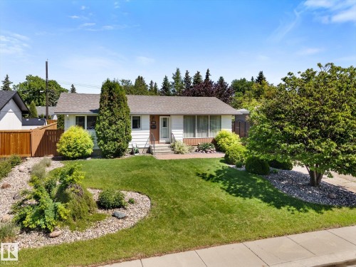 White siding residence with a brown shingle roof, featuring a concrete walkway to the front entrance - 15112 76A Avenue, Edmonton, AB 