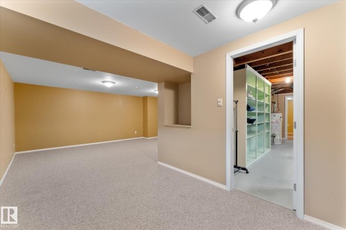 Finished lower level with neutral carpet flooring, recessed ceiling lighting, and a built-in wall niche - 15112 76A Avenue, Edmonton, AB 