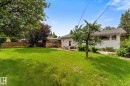 Expansive green lawn with mature trees and a private patio area - 15112 76A Avenue, Edmonton, AB 